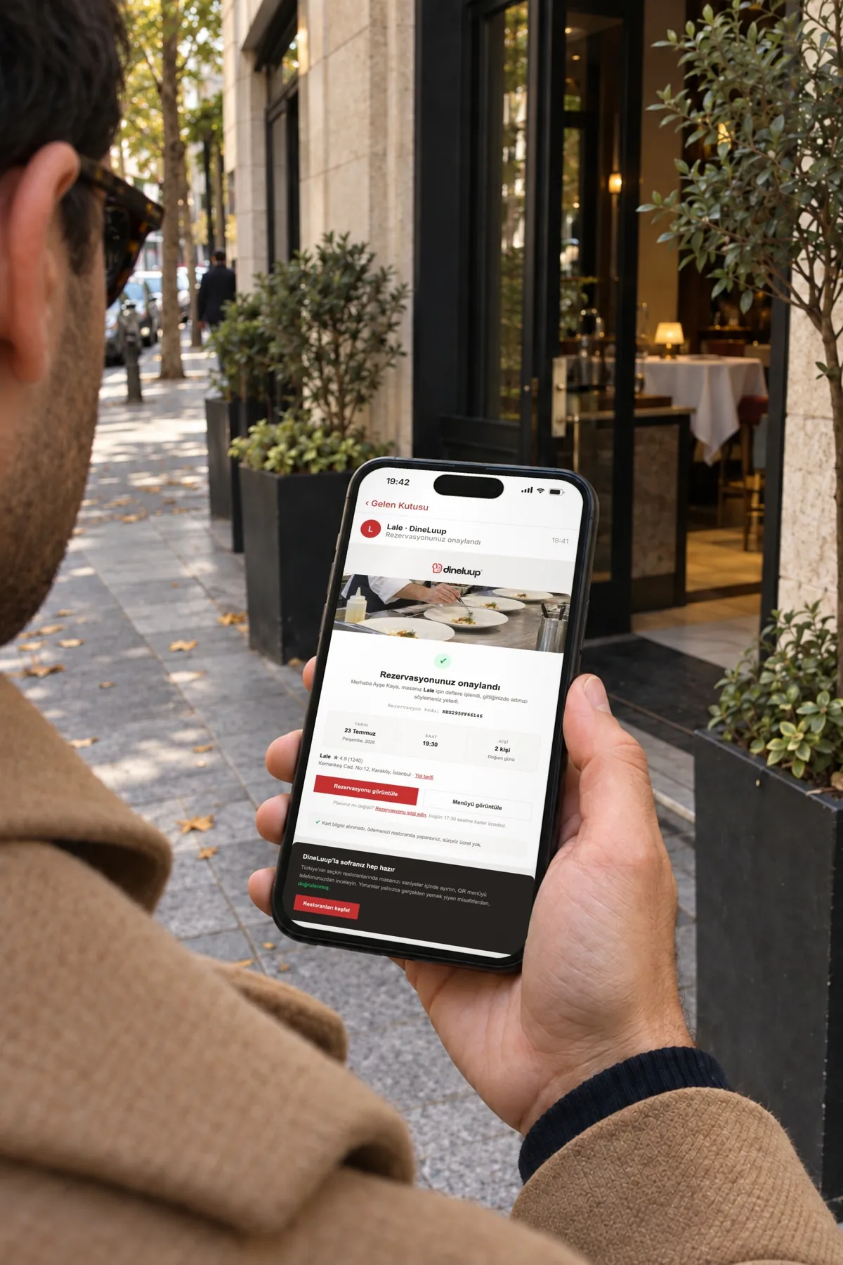 Restoran kapısında onay e-postasını okuyan misafir